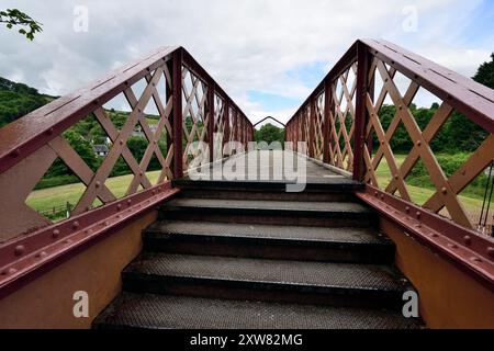 Treppen auf der Fußgängerbrücke über die Eisenbahnlinie am Bahnhof Buckfastleigh an der South Devon Railway. Stockfoto