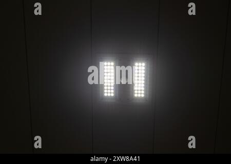 LED-Deckenleuchten beleuchten einen dunklen Raum – schlankes, modernes Design. Aufgenommen in Toronto, Kanada. Stockfoto