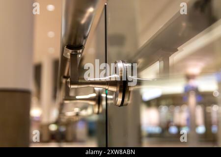 Nahaufnahme einer modernen Glastür mit Edelstahl-Armaturen in einer kommerziellen Umgebung. Aufgenommen in Toronto, Kanada. Stockfoto