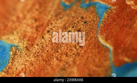 Funkelnde Flüssigkeit. Glitzerwelle. Unschärfe orange goldene blaue Farbe schimmernde Partikel Textur Farbstrom Bokeh heller abstrakter Kunsthintergrund. Stockfoto