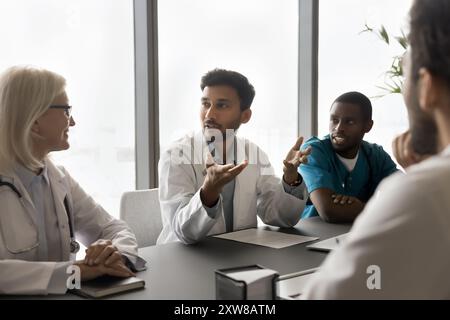 Verschiedene Ärzte hören indischen Kollegen zu, diskutieren Behandlungsmöglichkeiten, tauschen Meinungen aus Stockfoto