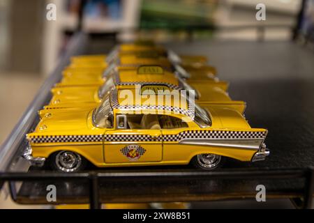 Eine Reihe von gelben Minitaxis, die auf einem Regal stehen - klassisches New York City Checker Taxi Design. Aufgenommen in Toronto, Kanada. Stockfoto