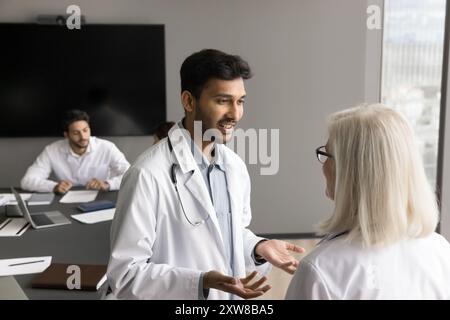 Zwei medizinische Fachkräfte, die im Besprechungsraum diskutiert werden Stockfoto