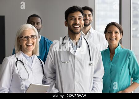 Fünf multiethnische Pflegekräfte in Uniformen, die sich in der Klinik ausgeben Stockfoto