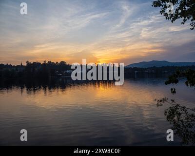 Ein atemberaubender Sonnenuntergang wirft goldene Farbtöne über dem Lake Placid und spiegelt die ruhige Schönheit der Adirondack Mountains über dem Mirror Lake wider Stockfoto