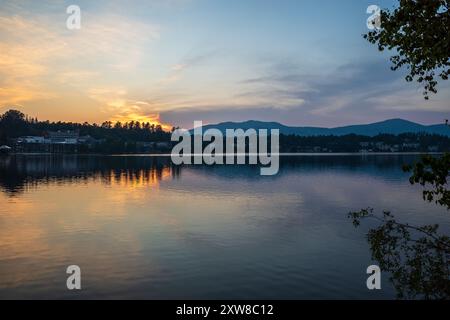 Ein atemberaubender Sonnenuntergang wirft goldene Farbtöne über dem Lake Placid und spiegelt die ruhige Schönheit der Adirondack Mountains über dem Mirror Lake wider Stockfoto