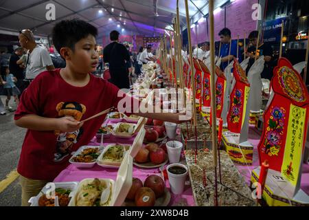 Kuala Lumpur, Malaysia. August 2024. Chinesische Gläubige bereiten während des Hungry Ghost Festivals in Kota Damansara Opfer vor. Das Hungry Ghost Festival fällt am 15. Tag des siebten Mondmonats. Die chinesischen Gläubigen glaubten, dass sich die Tore der Hölle öffnen und Geister in diesem Monat die menschliche Welt durchstreifen. Quelle: SOPA Images Limited/Alamy Live News Stockfoto