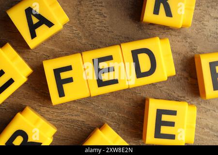 Würfel mit den Buchstaben Fed (Federal Reserve System) auf Holztisch, flach gelegt Stockfoto