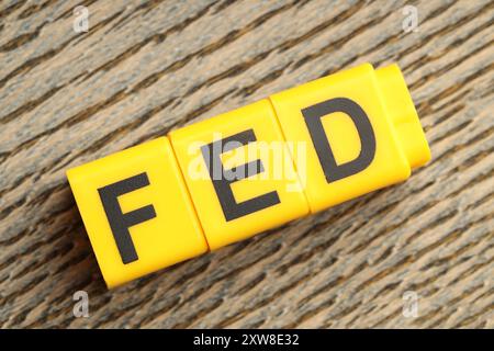 Würfel mit den Buchstaben Fed (Federal Reserve System) auf Holztisch, Draufsicht Stockfoto