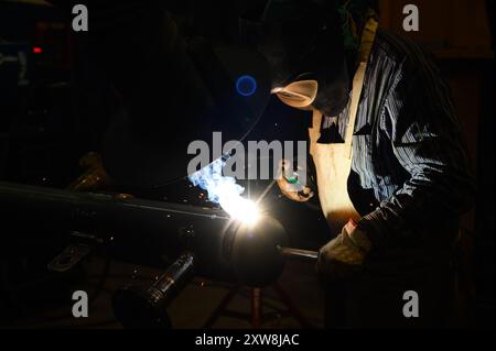 Arbeiter, der einen Winkelschleifer betreibt und viele Funken erzeugt Stockfoto