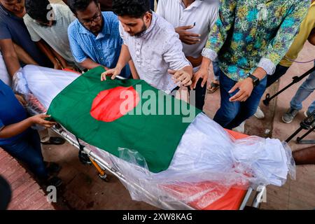 Dhaka, Bangladesch. August 2024. Aktivisten der Anti-Diskriminierungsbewegung tragen eine Leiche, die mit der Nationalflagge bedeckt ist, während sie am 18. August 2024 an der Beerdigung zweier Mitschüler im Zentrum von Shaheed Minar in Dhaka, Bangladesch, teilnehmen. Laut der Anti-Diskriminierungsbewegung erlagen zwei Studenten, die als MD Emon und Mohammad Riyaz identifiziert wurden, die während der Auseinandersetzungen im Zusammenhang mit der Quotenreformbewegung verletzt wurden, in einem Krankenhaus in Dhaka ihren Verletzungen. (Kreditbild: © Suvra Kanti das/ZUMA Press Wire) NUR REDAKTIONELLE VERWENDUNG! Nicht für kommerzielle ZWECKE! Stockfoto