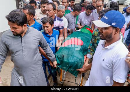 Dhaka, Bangladesch. August 2024. Aktivisten der Anti-Diskriminierungsbewegung tragen eine Leiche, die mit der Nationalflagge bedeckt ist, während sie am 18. August 2024 an der Beerdigung zweier Mitschüler im Zentrum von Shaheed Minar in Dhaka, Bangladesch, teilnehmen. Laut der Anti-Diskriminierungsbewegung erlagen zwei Studenten, die als MD Emon und Mohammad Riyaz identifiziert wurden, die während der Auseinandersetzungen im Zusammenhang mit der Quotenreformbewegung verletzt wurden, in einem Krankenhaus in Dhaka ihren Verletzungen. (Kreditbild: © Suvra Kanti das/ZUMA Press Wire) NUR REDAKTIONELLE VERWENDUNG! Nicht für kommerzielle ZWECKE! Stockfoto