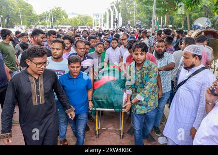 Dhaka, Bangladesch. August 2024. Aktivisten der Anti-Diskriminierungsbewegung tragen eine Leiche, die mit der Nationalflagge bedeckt ist, während sie am 18. August 2024 an der Beerdigung zweier Mitschüler im Zentrum von Shaheed Minar in Dhaka, Bangladesch, teilnehmen. Laut der Anti-Diskriminierungsbewegung erlagen zwei Studenten, die als MD Emon und Mohammad Riyaz identifiziert wurden, die während der Auseinandersetzungen im Zusammenhang mit der Quotenreformbewegung verletzt wurden, in einem Krankenhaus in Dhaka ihren Verletzungen. (Kreditbild: © Suvra Kanti das/ZUMA Press Wire) NUR REDAKTIONELLE VERWENDUNG! Nicht für kommerzielle ZWECKE! Stockfoto