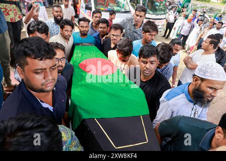 Dhaka, Bangladesch. August 2024. Aktivisten der Anti-Diskriminierungsbewegung tragen eine Leiche, die mit der Nationalflagge bedeckt ist, während sie am 18. August 2024 an der Beerdigung zweier Mitschüler im Zentrum von Shaheed Minar in Dhaka, Bangladesch, teilnehmen. Laut der Anti-Diskriminierungsbewegung erlagen zwei Studenten, die als MD Emon und Mohammad Riyaz identifiziert wurden, die während der Auseinandersetzungen im Zusammenhang mit der Quotenreformbewegung verletzt wurden, in einem Krankenhaus in Dhaka ihren Verletzungen. (Kreditbild: © Suvra Kanti das/ZUMA Press Wire) NUR REDAKTIONELLE VERWENDUNG! Nicht für kommerzielle ZWECKE! Stockfoto