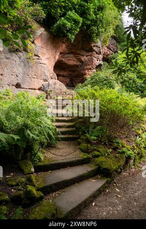 Die Gärten in Quarry Bank, Styal, Cheshire, England. Eine Höhle in den Sandsteinklippen in der Nähe des alten Hauses. Stockfoto