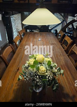 Hochzeitsstrauß aus Rosen, gypsophila und Eukalyptus in einer Vase auf einem rustikalen Holztisch drinnen, bevor die Hochzeit beginnt. Modra, Slowakei. Stockfoto