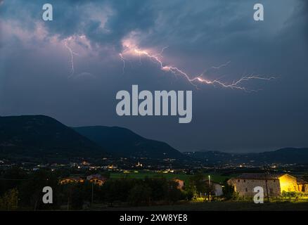 Während einer stürmischen Nacht blitzte ein Blitz über den italienischen Alpen Stockfoto