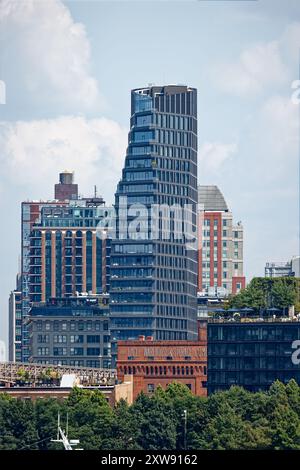 Riesige segelförmige Olympia DUMBO Eigentumswohnungen erhebt sich hinter dem Wahrzeichen Eagle Warehouse & Storage in dieser Aussicht von einer East River Fähre. Stockfoto