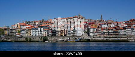 Porto, Portugal - 18. August 2022: Panoramablick auf die Stadt porto mit dem douro im Vordergrund, Gebäuden der Stadt und blauem Himmel Stockfoto
