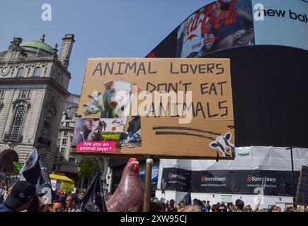 London, Großbritannien. August 2024. Ein Demonstrant hält während des National Animal Rights March im Piccadilly Circus ein Schild mit dem Titel „Animal Lovers don’t eat Animals“. Der jährliche Protest hebt das Leiden und den Tod von Milliarden von Tieren in allen Bereichen menschlichen Handelns hervor, kämpft für die Tierbefreiung und für ein Ende der Tierausbeutung und fördert Veganismus und einen grausamen Lebensstil. Quelle: SOPA Images Limited/Alamy Live News Stockfoto