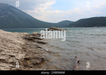 Ein Landschaftsbild der Berge rund um den Lake Minnewanka, aufgenommen vom felsigen Strand im Banff National Park, Kanada (29.07.24) Stockfoto