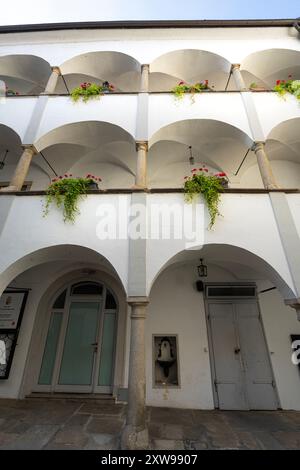 Linz, Österreich. August 2024. Außenansicht der Blumen auf dem Balkon in einem typischen Innenhof zwischen alten Gebäuden im Stadtzentrum Stockfoto