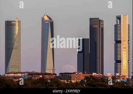 Madrid, Spanien. August 2024. Der fast Vollmond im August, bekannt als Sturgeon-Mond, erhebt sich über den Wolkenkratzern der Skyline Madrids, bekannt als Four Towers Business Area. Quelle: Marcos del Mazo/Alamy Live News Stockfoto