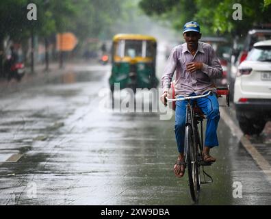 Neu-Delhi, Indien. August 2024. NOIDA, INDIEN – 18. AUGUST: Pendler treten bei Nachmittagsregen am Sektor 34 am 18. August 2024 in Noida, Indien aus. (Foto: Sunil Ghosh/Hindustan Times/SIPA USA) Credit: SIPA USA/Alamy Live News Stockfoto