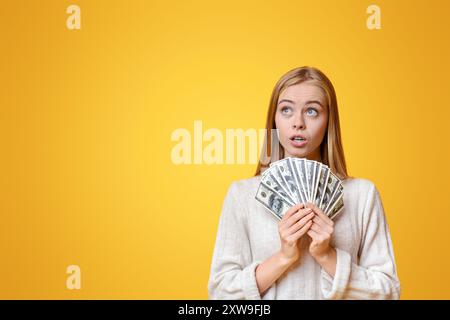 Nachdenkliches Mädchen, dass Bündel von Dollar und Nach oben Suche Stockfoto