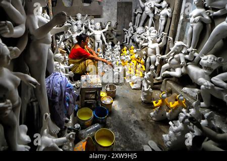 Kalkutta, Indien. August 2024. Vor dem bevorstehenden Viswakarma-Festival verleiht eine Künstlerin den Idolen des Hindu-Lord Viswakarma in dem Geschäft in der Gegend von Kumortuli, wo religiöse Statuen gefertigt werden, einen letzten Schliff. Das Ganesh Chaturthi Festival ist das jährliche Gottesfest der Hindus und es wird angenommen, dass Lord Ganesha der Gott der Neuanfänge und der Beseitigung von Hindernissen sowie der Gott der Weisheit, Intelligenz, des Reiches und des Wohlstands ist. Quelle: SOPA Images Limited/Alamy Live News Stockfoto