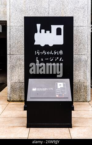 Informationstafel am Eingang des Botchan Train Museum, im Stadtzentrum von Matsuyama, Region Shikoku, Japan Stockfoto