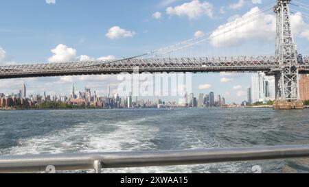 Skyline von New York City von der Fähre aus. Manhattan Midtown Hochhäuser, Fähre. Hafenpanorama am East River, Architektur am Fluss, USA. Williamsburg Bridge, Empire State Building. Stockfoto