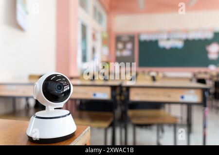 Geschlossenes Fernsehen, Sicherheits-CCTV-Kamera oder Überwachungssystem im Hintergrund. Ein Klassenzimmer mit einer an der Decke montierten Kamera Stockfoto