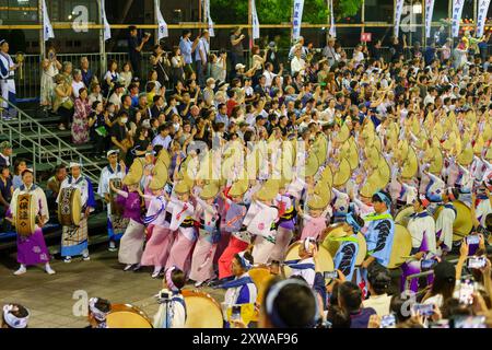 Tokushima Awa Odori Festival 2024 Soodori. Alle Darsteller tanzen und singen in einer Formation, während sie nachts durch die Bühne im Freien ziehen. Stockfoto