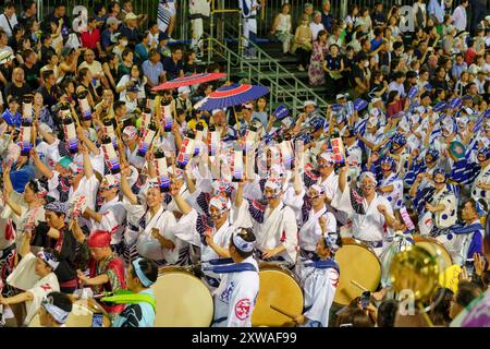 Tokushima Awa Odori Festival 2024 Soodori. Alle Darsteller tanzen und singen in einer Formation, während sie nachts durch die Bühne im Freien ziehen. Stockfoto