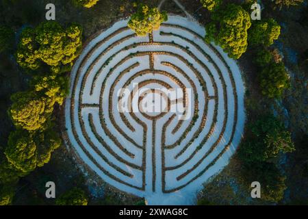 Aus der Vogelperspektive des kreisrunden Heckenlabyrinths umgeben von dichten Waldbäumen. Lavendellabyrinth in Rogoznica, Kroatien Stockfoto