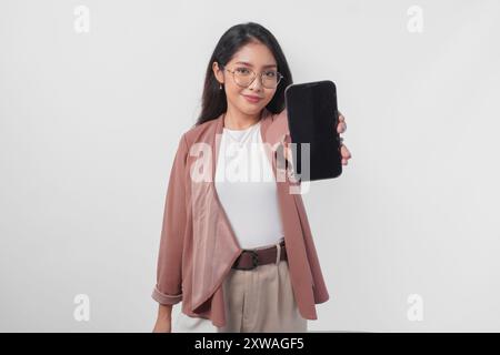 Schöne asiatische Geschäftsfrau in Brille, die Kopierraum auf ihrem Telefonbildschirm präsentiert, isoliert durch weißen Hintergrund. Stockfoto