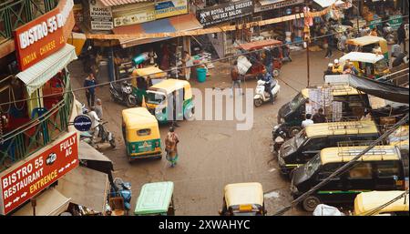 New Delhi, Delhi, Indien - 4. Februar 2024: Verkehr auf der Hauptbasarstraße Straße Paharganj. Autos, Motorräder, Auto Rikscha oder Tuk-Tuk fahren weiter Stockfoto