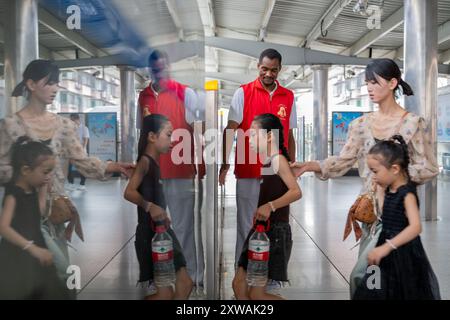 (240819) -- WUHAN, 19. August 2024 (Xinhua) -- Lugazo Abubakar Lugazo (hinten) führt Menschen an einem Bahnhof in Wuhan, Zentralchinas Provinz Hubei, 18. August 2024 an Bord einer U-Bahn. Lugazo Abubakar Lugazo, ein 30-jähriger Tansania, promoviert derzeit an der Central China Normal University (CCNU) in Wuhan. Neben seinem Studium ist er auch Leiter eines Freiwilligen-Service-Teams, das sich aus internationalen Studenten zusammensetzt. Lugazos Zuneigung für China begann während seines Bachelorstudiums in Tansania. Ermutigt von einem chinesischen Lehrer an einem Konfuzius-Institut, begann Lugazo seine Reise Stockfoto