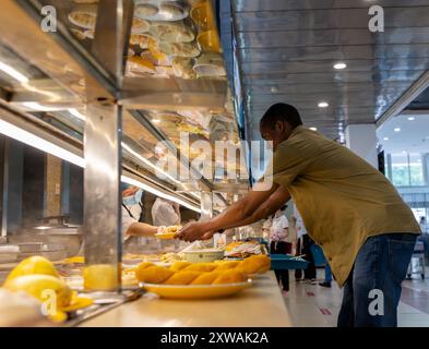 (240819) -- WUHAN, 19. August 2024 (Xinhua) -- Lugazo Abubakar Lugazo bekommt eine Mahlzeit in einer Kantine der Central China Normal University in Wuhan, Zentralchinas Provinz Hubei, 24. Juni 2024. Lugazo Abubakar Lugazo, ein 30-jähriger Tansania, promoviert derzeit an der Central China Normal University (CCNU) in Wuhan. Neben seinem Studium ist er auch Leiter eines Freiwilligen-Service-Teams, das sich aus internationalen Studenten zusammensetzt. Lugazos Zuneigung für China begann während seines Bachelorstudiums in Tansania. Angeregt von einem chinesischen Lehrer an einem Konfuzius-Institut, begann Lugazo sein Jo Stockfoto