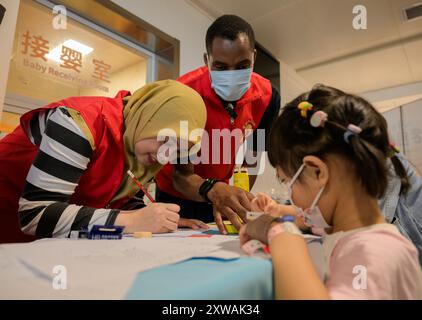 (240819) -- WUHAN, 19. August 2024 (Xinhua) -- Lugazo Abubakar Lugazo (C) interagiert mit Kindern während einer freiwilligen Tätigkeit in einem Krankenhaus in Wuhan, Zentralchinas Provinz Hubei, 31. Mai 2024. Lugazo Abubakar Lugazo, ein 30-jähriger Tansania, promoviert derzeit an der Central China Normal University (CCNU) in Wuhan. Neben seinem Studium ist er auch Leiter eines Freiwilligen-Service-Teams, das sich aus internationalen Studenten zusammensetzt. Lugazos Zuneigung für China begann während seines Bachelorstudiums in Tansania. Angeregt von einem chinesischen Lehrer an einem Konfuzius-Institut, ging Lugazo an den Start Stockfoto