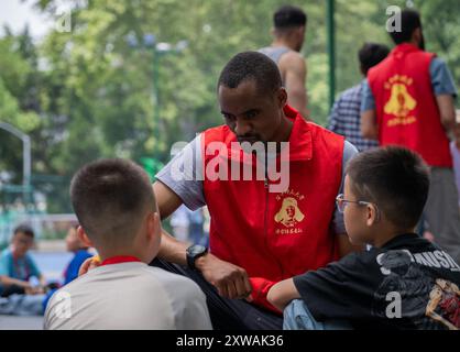 (240819) -- WUHAN, 19. August 2024 (Xinhua) -- Lugazo Abubakar Lugazo interagiert mit Kindern während einer Freiwilligentätigkeit in Wuhan, Zentralchinas Provinz Hubei, 19. Mai 2024. Lugazo Abubakar Lugazo, ein 30-jähriger Tansania, promoviert derzeit an der Central China Normal University (CCNU) in Wuhan. Neben seinem Studium ist er auch Leiter eines Freiwilligen-Service-Teams, das sich aus internationalen Studenten zusammensetzt. Lugazos Zuneigung für China begann während seines Bachelorstudiums in Tansania. Ermutigt von einem chinesischen Lehrer an einem Konfuzius-Institut, begann Lugazo seine Reise Stockfoto