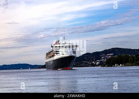 Kreuzfahrt-Schiff Queen Mary 2 in Byfjorden, Abfahrt vom Jekteviksterminalen Kai, im Hafen von Bergen, Norwegen. Stockfoto