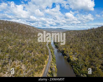 Tasmanien, Australien: Luftbild der Straße am Prosser River in der Nähe von Orford in den Hügeln der tasmanischen Landschaft durch einen dichten Wald. Stockfoto