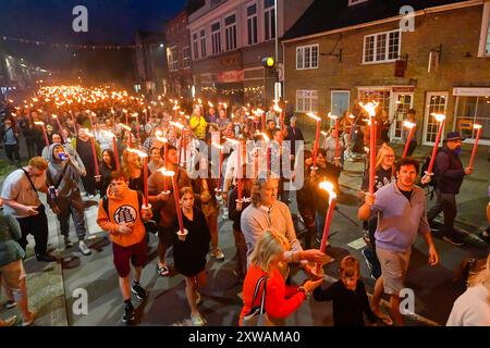 Bridport, Dorset, Großbritannien. August 2024. Hunderte von Menschen mit brennenden Fackeln nehmen an der jährlichen Bridport Carnival Fackelprozession Teil. Die Two Mile-Prozession begann in der Bridport Town Hall und endete am East Beach in West Bay in Dorset. Bildnachweis: Graham Hunt/Alamy Live News Stockfoto