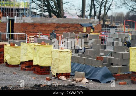 Rote Ziegelsteine und Betonblöcke auf der Baustelle geliefert und fertig für Maurer Stockfoto