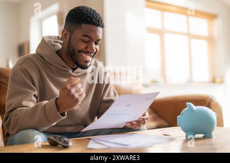 Glücklicher Mann liest Brief Antwort auf seine Bewerbung Darlehen Hypothek glücklich lächelnd aufgeregt Stockfoto
