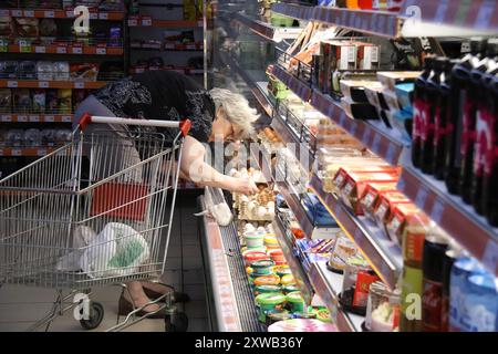 KRAMATORSK, UKRAINE - 17. AUGUST 2024 - Eine Frau holt Eier in einem Supermarkt in Kramatorsk, einer Stadt in der Region Donezk, Ostukraine, in der Nähe der Front. Stockfoto