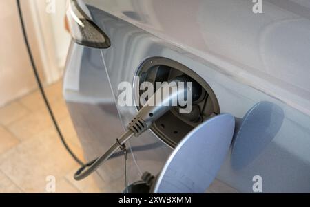 Elektroauto, das zu Hause aufgeladen wird, von einer installierten Wallbox. Hochwinkelansicht. Stockfoto