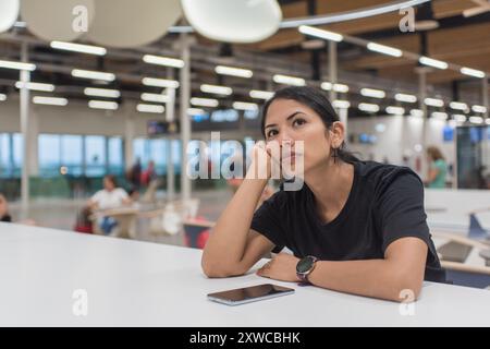 Frau langweilte sich im Flughafenterminal und wartete auf ihren Flug. Stockfoto